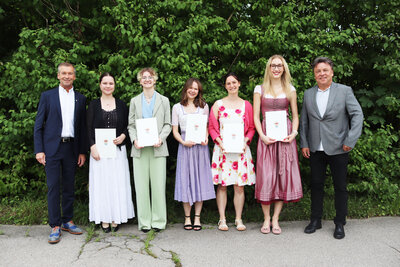 Bild vergr&ouml;&szlig;ern: Landrat Jens Zangenfeind (l.) und Schulleiter Stefan Schellenberger (r.) gratulieren Anna Jordan, Theresa Weigl, Cornelia Scheuerer, Caralina Sonnekalb und Pia Teupe (v.l.) von der FOS Holzkirchen.