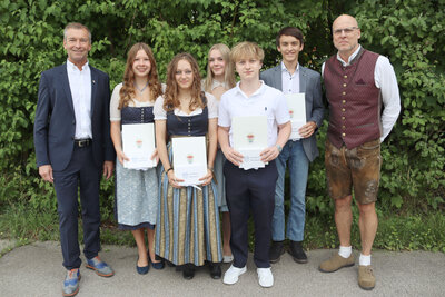 Bild vergr&ouml;&szlig;ern: Landrat Jens Zangenfeind (l.) und Schulleiter Joachim Fischer (r.) gratulieren Celina Schmidpeter, Verena Zinsbacher, Marie-Sophie Neuhofer, Finn B&uuml;rkner und Dominik Fugger (v.l.) von der Realschule Holzkirchen.